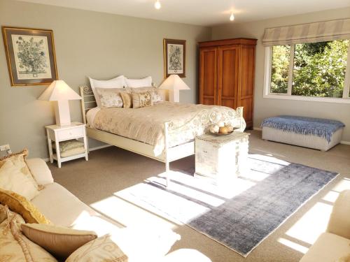 a bedroom with a bed and a couch at Centennial House Taupo in Taupo