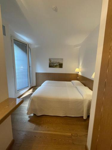 a bedroom with a white bed and a window at Hotel Metropole Suisse in Como