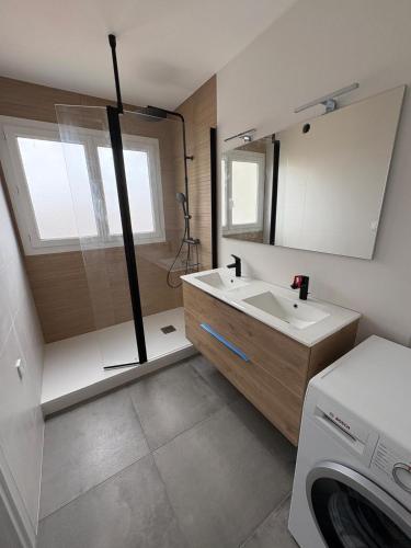 une salle de bain avec un lavabo et une machine à laver dans l'établissement Vue sur Mer Appartement les Sables d'Olonne - 6 personnes, à Les Sables-dʼOlonne