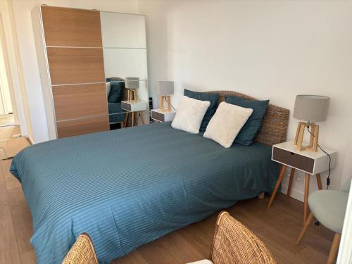 une chambre avec un lit bleu et un miroir dans l'établissement Vue sur Mer Appartement les Sables d'Olonne - 6 personnes, à Les Sables-dʼOlonne