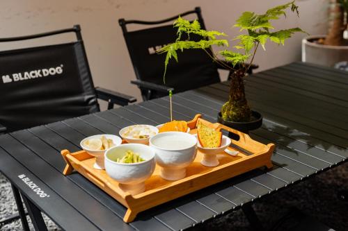 een dienblad met kommen eten op een tafel bij 花筑其间 咖啡民宿丨西湖区灵隐寺店 in Hangzhou