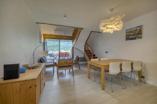 une salle à manger et un salon avec une table et des chaises dans l'établissement Les jardins du lac - OG IMMO, à Duingt
