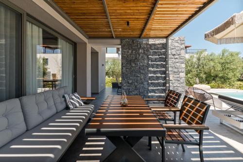 a patio with a wooden table and chairs on a patio at Dionisos Luxury Villas in Pefkohori