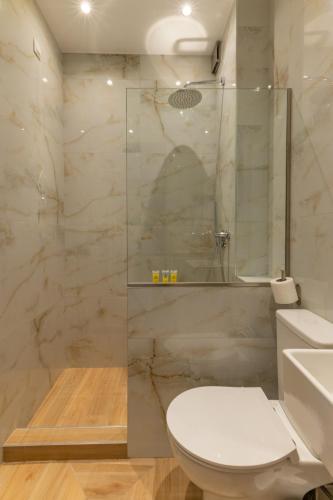 a bathroom with a toilet and a glass shower at Hotel Kaikis in Kalabaka