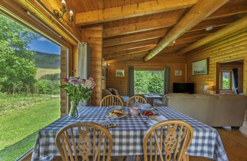 a dining room with a table and chairs in a cabin at Finest Retreats - Cragdhu Log Cabin in Glenshee