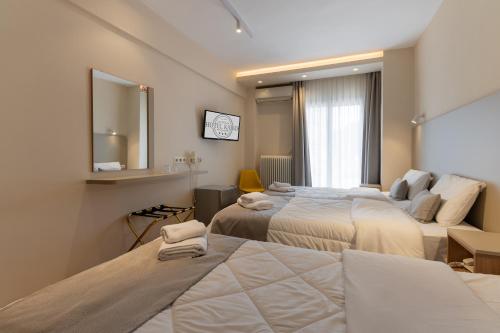 a hotel room with two beds and a mirror at Hotel Kaikis in Kalabaka