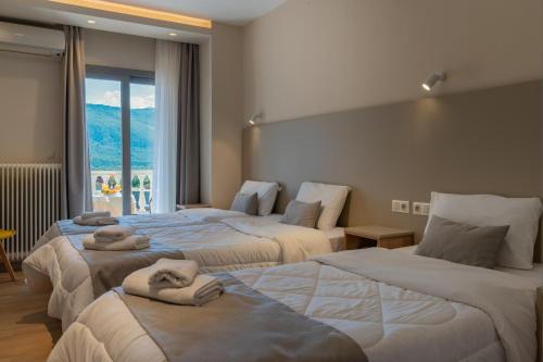 a hotel room with two beds with towels on them at Hotel Kaikis in Kalabaka