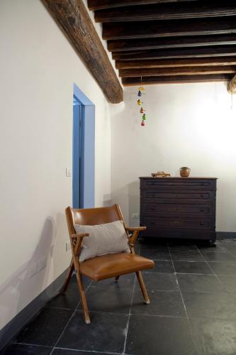 a wooden chair sitting in a room with a dresser at Affittacamere Bernardo Ricci in Albenga