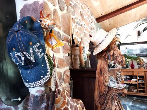 a giraffe and a woman wearing a hat next to a wall at Villa Isabelle in Aywaille