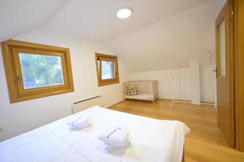 a bedroom with a white bed and a window at Vila Fruškica in Vrdnik