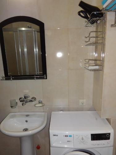 uma casa de banho com um lavatório, um WC e um espelho. em Buoy Rooms em Batumi