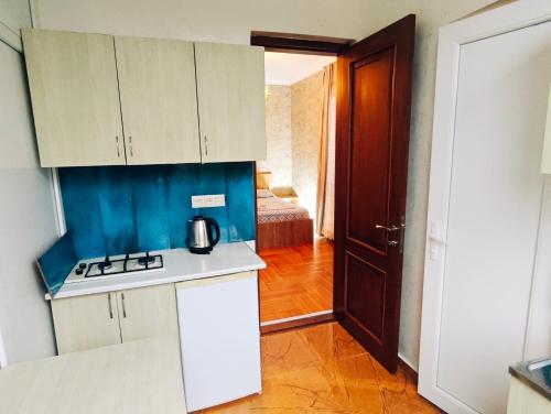 a kitchen with white cabinets and a stove top oven at Guesthouse Mery in K'obulet'i