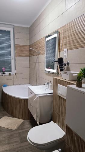 a bathroom with a tub and a toilet and a sink at Panoráma 4U in Tapolca