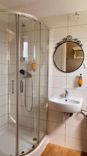 a bathroom with a shower and a sink and a mirror at Dworek Golikowo in Sławno