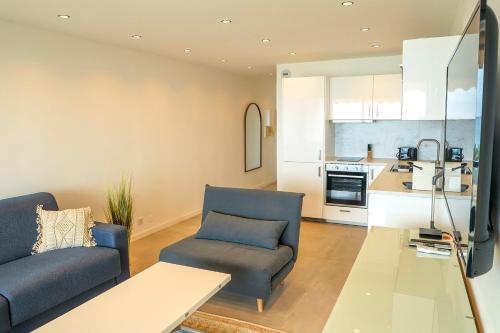un salon avec deux canapés bleus et une cuisine dans l'établissement STUDIO Luxe CENTER BAY 4, à Antibes