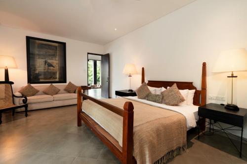 a bedroom with a large bed and a couch at Lily Pod in Panadura