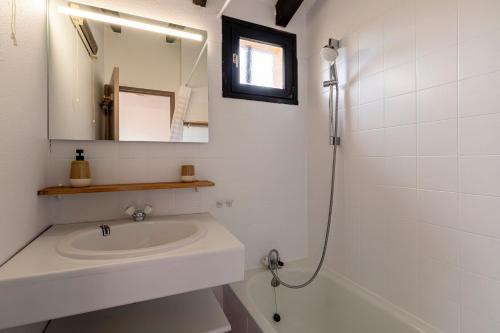 une salle de bain blanche avec un lavabo et un miroir dans l'établissement La Petite Felicità - Jolie Vue sur la Baie d'Ajaccio, à Grosseto-Prugna