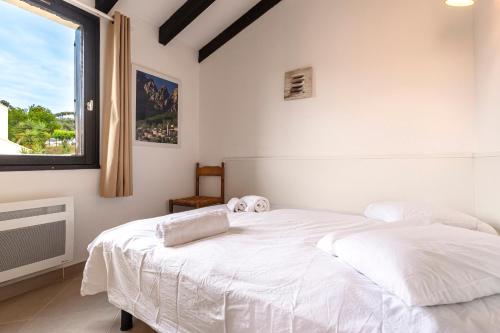 - un lit blanc dans une chambre avec fenêtre dans l'établissement La Petite Felicità - Jolie Vue sur la Baie d'Ajaccio, à Grosseto-Prugna