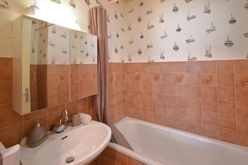 a bathroom with a sink and a bath tub at Le Gîte de l’Estuaire - Proche Plage in Saint-Georges-de-Didonne