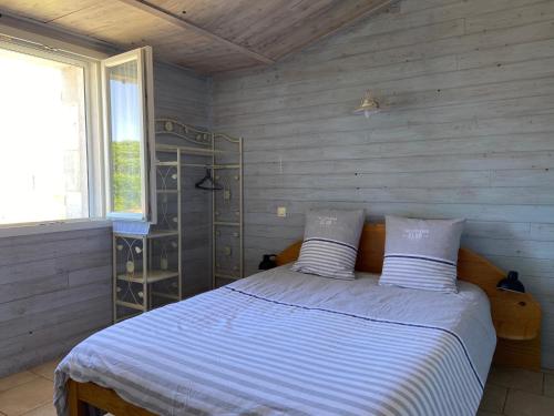 une chambre avec un lit avec des draps blancs et une fenêtre dans l'établissement Océan, au Château-dʼOléron