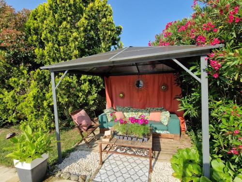een zwart paviljoen met een bank en een tafel bij Maison 10 personnes Golf - Hippodrome in Montauban