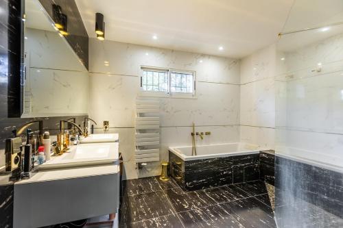 a bathroom with two sinks and a bath tub at Villa avec piscine in Cabestany