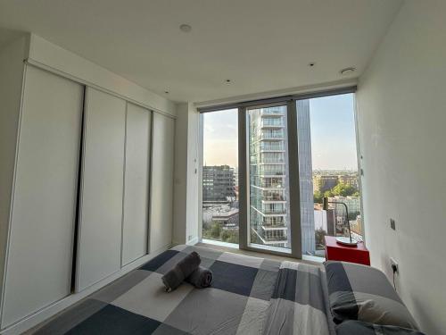 a bedroom with a bed with a large window at Luxury 1BR with Balcony & City Views near Aldgate in Moffat