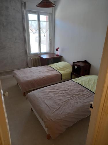 deux lits dans une chambre avec une fenêtre dans l'établissement Chambres meublées, à Berchères-les-Pierres