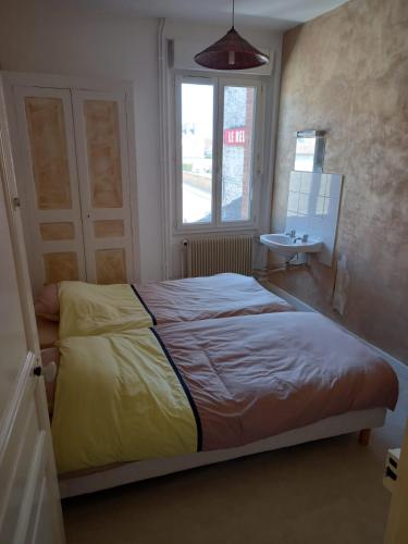une chambre avec un lit, un lavabo et une fenêtre dans l'établissement Chambres meublées, à Berchères-les-Pierres