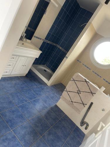una cucina con pavimenti piastrellati blu e una finestra di Villa Pierre boulât 66 a Perpignano