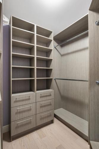 a walk in closet with wooden shelves and cabinets at The Royal Ravine Luxury Retreat with Hot Tub & Sauna in Calgary