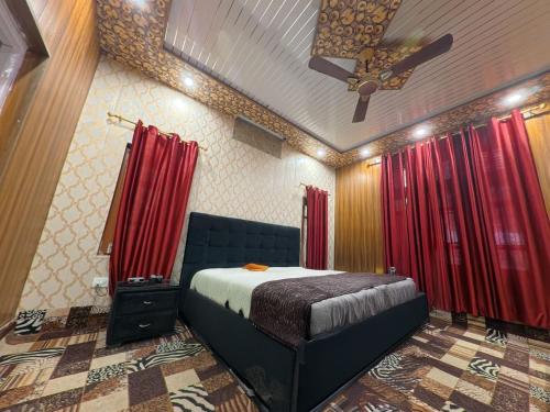 a bedroom with a bed with red curtains and a ceiling at Villa Royale in Kūd