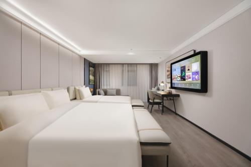 a hotel room with two beds and a flat screen tv at Atour X Hotel Xi'an Bell Tower Subway Station in Xi'an