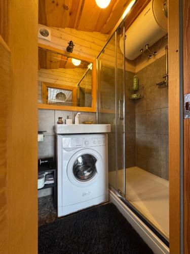 a washing machine in a bathroom with a shower at Goldingen Stone Retreat - Hot Tub and Nature in Kuldīga