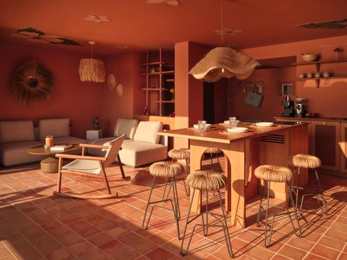a kitchen and living room with a table and stools at Bikini Island & Mountain Hotel Es Trenc -Adults only- in Colonia Sant Jordi