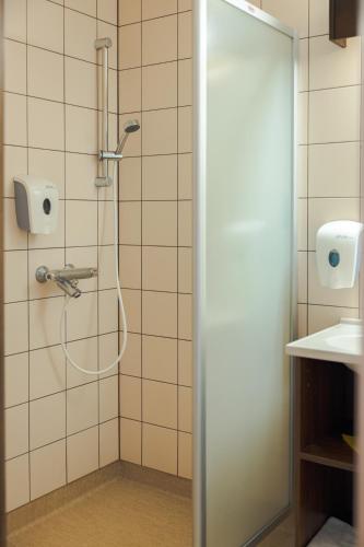 a shower with a hose in a bathroom at Meriniitty Hotelli in Salo