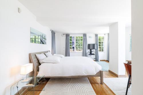 a white bedroom with a bed and a desk at Villa Ocean Breeze in Roquebrune-Cap-Martin