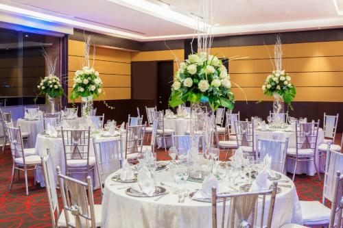 a room filled with tables and chairs with flowers at Sonesta Hotel Cali in Cali