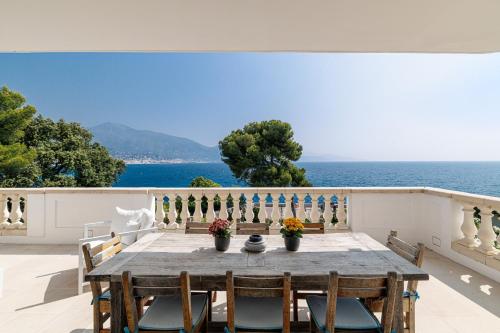 a table with chairs and a view of the ocean at Villa Ocean Breeze in Roquebrune-Cap-Martin