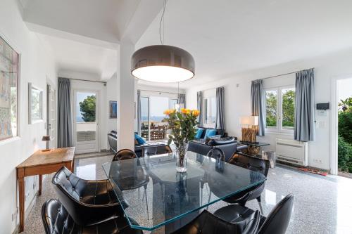a living room with a glass table and chairs at Villa Ocean Breeze in Roquebrune-Cap-Martin