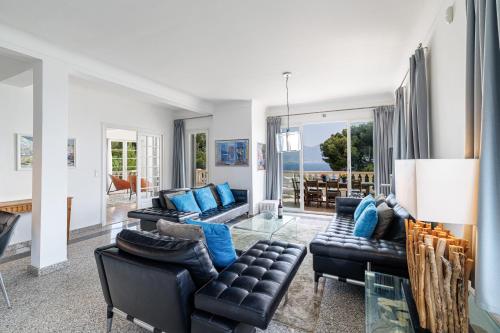 a living room with black leather couches and blue pillows at Villa Ocean Breeze in Roquebrune-Cap-Martin