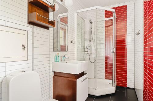 a white bathroom with a sink and a shower at Trolltunga Fjord Living in Tysso