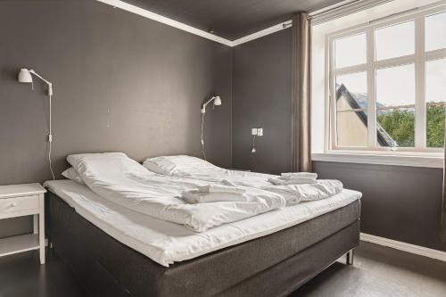 a large bed in a room with a window at Trolltunga Fjord Living in Tysso