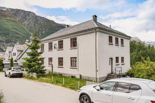 a white house with a car parked in front of it at Trolltunga Fjord Living in Tysso