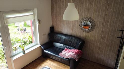 a black leather chair in a room with a window at Haus Hönigblick in Wilnsdorf