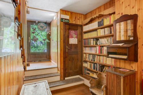 a library with wooden walls and book shelves with books at Agriturismo Les Ecureuils in Saint-Pierre