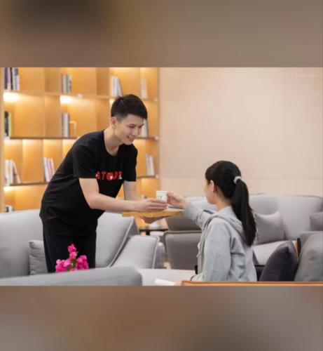 a man and a girl in a room at Atour Hotel Shenzhen Fuhai International Convention and Exhibition Center in Bao'an