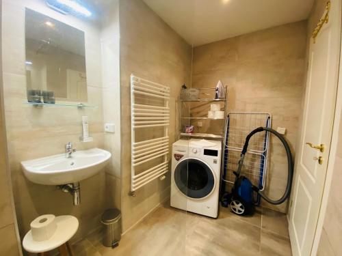 a bathroom with a washing machine and a sink at Amaroo - Apartments "Andy" in Potsdam