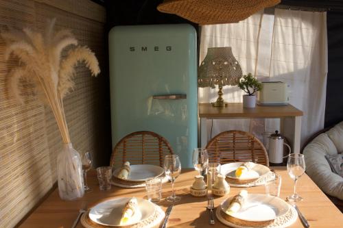 亚斯塔尔尼亚Przyczepa Surfzen Jastarnia的餐桌,带餐盘和酒杯