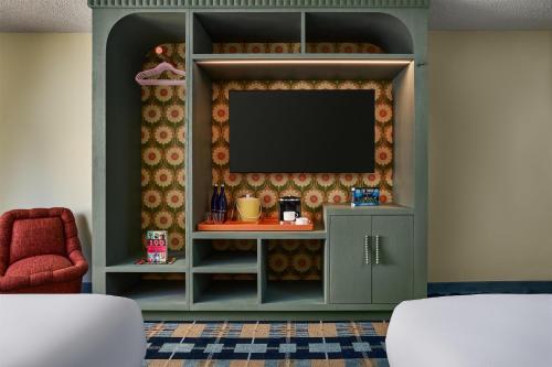 a living room with a tv on a wall at the Curtis Denver - A DoubleTree by Hilton Hotel in Denver